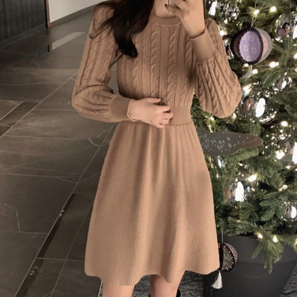 Vrouw in beige gebreide jurk naast kerstboom, elegante wintermode, feestelijke kleding, stijlvolle outfit voor de feestdagen, binnenomgeving.