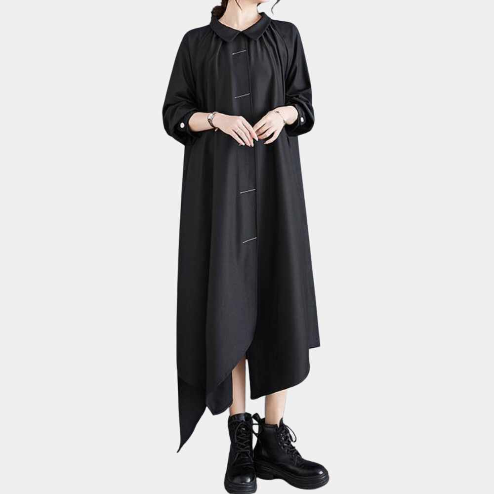 Zwarte asymmetrische maxi-jurk met lange mouwen en knoopsluiting, gedragen met zwarte laarzen. Modieuze dameskleding, eigentijds design.