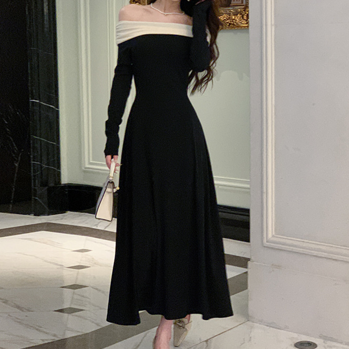 Elegante zwarte off-shoulder jurk, lange mouwen, vloerlengte, gedragen door vrouw in chique interieur. Perfect voor avondkleding en formele gelegenheden.