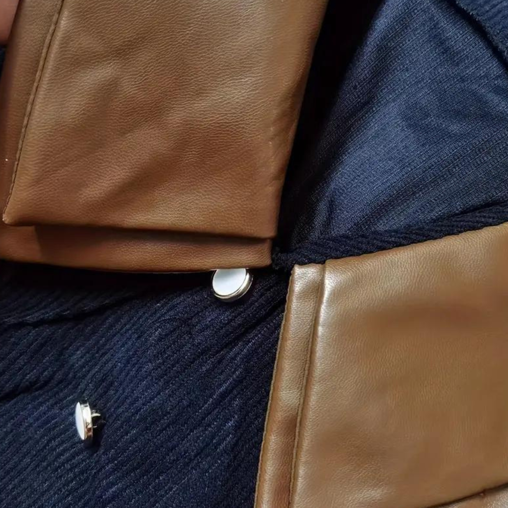 Bruine leren jas met zilveren knopen op donkerblauwe stof. Hoogwaardige materialen, stijlvolle mode, herfst- en winterkleding.