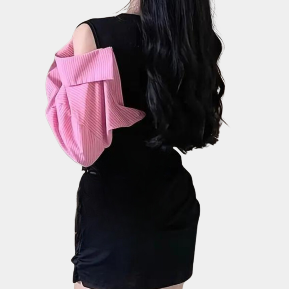 Vrouw in zwarte jurk met roze trui over schouder, lange zwarte haren. Mode, trendy kleding, stijlvolle outfit, casual chic look.