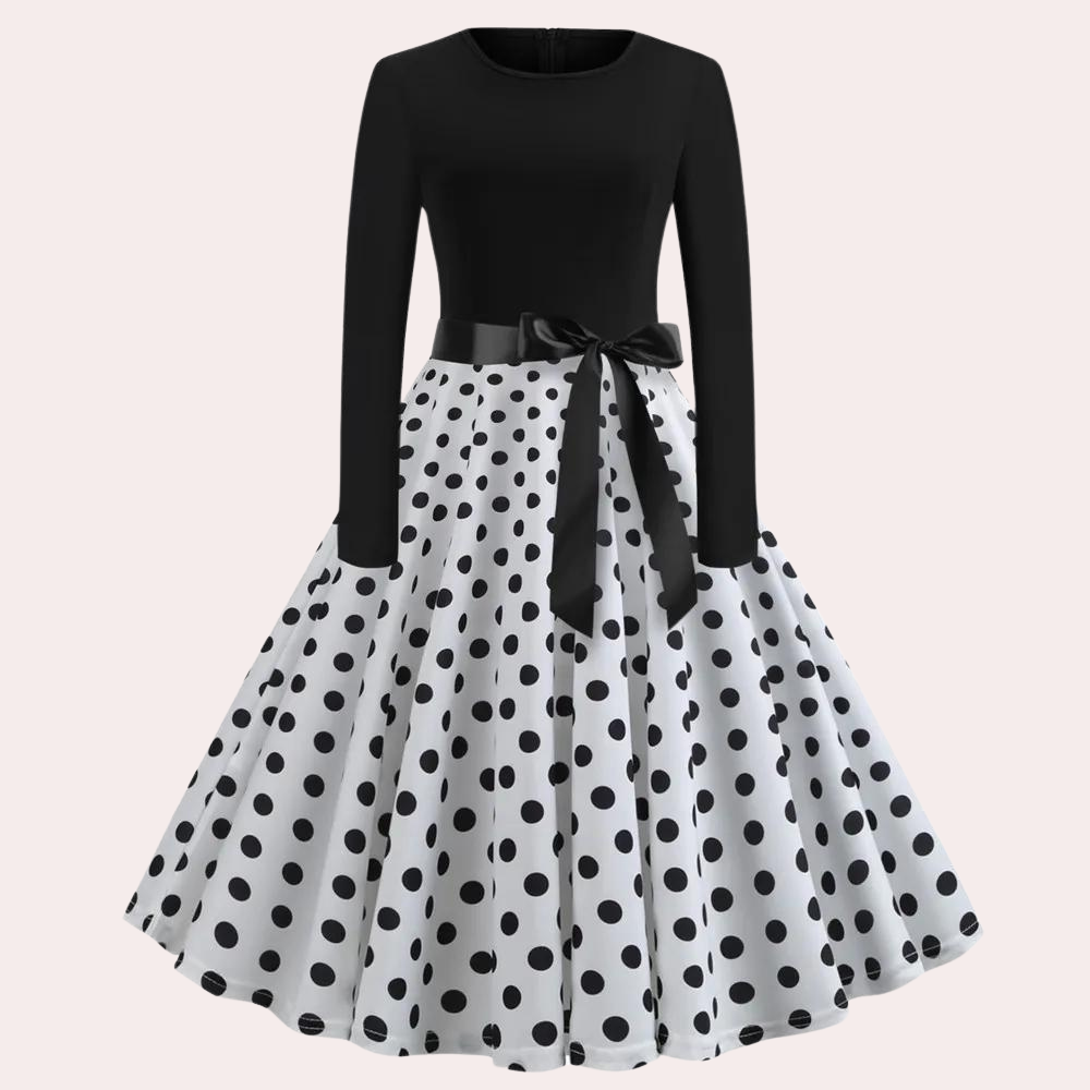 Zwart-witte polkadot jurk met lange mouwen en strik, retro stijl, elegante damesmode, perfect voor feestjes en speciale gelegenheden.
