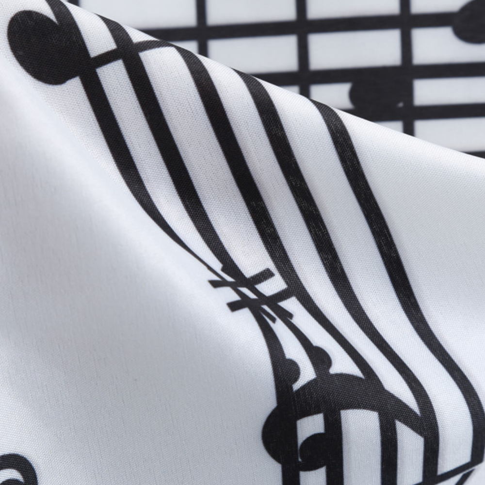 Zwart-witte muzieknotenprint op glanzende stof, close-up. Perfect voor muzikale decoratie, kledingontwerp, creatieve textieltoepassingen.