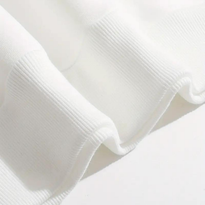 Witte geribbelde stof close-up, zachte textuur, geschikt voor kleding en interieur, hoogwaardige textielmaterialen, moderne stofontwerp.