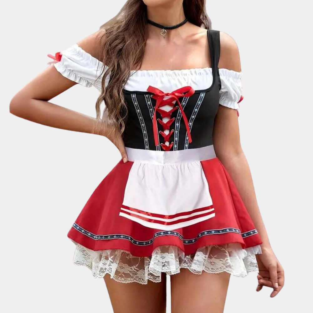 Vrouw in traditionele Duitse dirndl jurk met rood-wit-zwart ontwerp, kanten details en schort. Oktoberfest mode, feestkleding, kostuum.