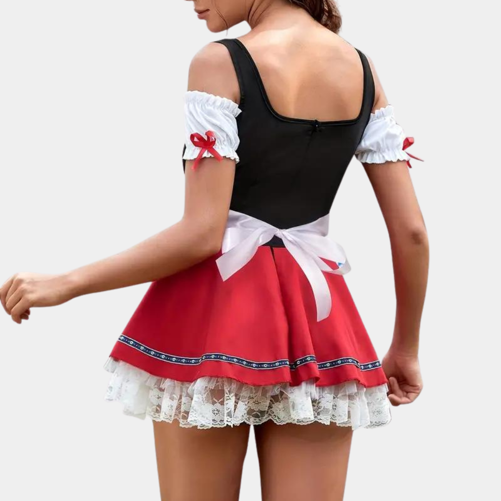 Vrouw in traditioneel Beiers dirndl kostuum, zwart bovenstuk, rode rok met witte kanten onderlaag en strik, Oktoberfest kleding.