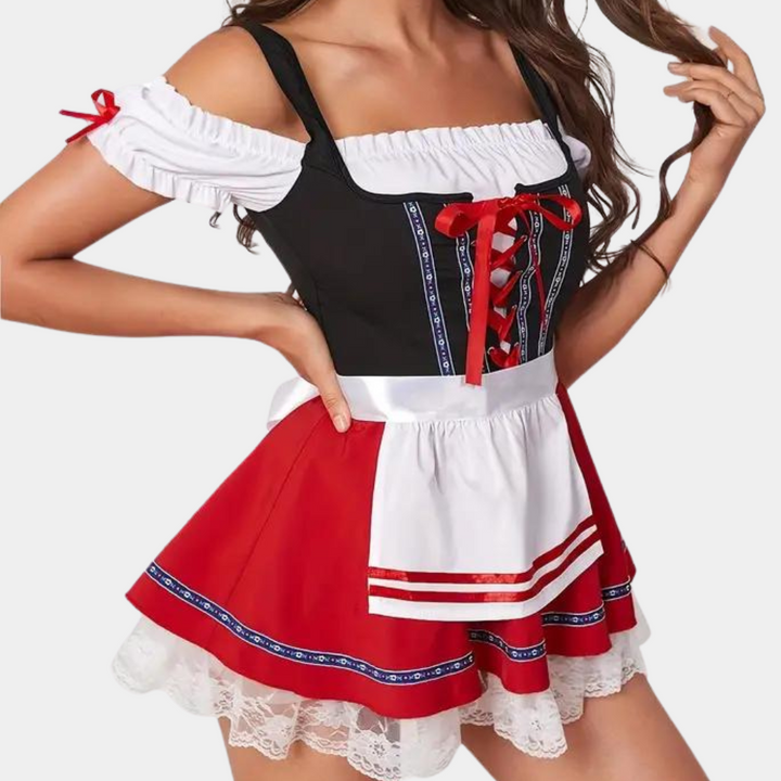Vrouw in traditionele Duitse dirndl jurk met rood-wit-zwart ontwerp, kanten details en schoudervrije top. Oktoberfest kleding, feestkostuum.