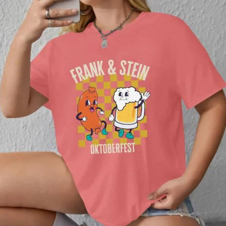 Vrouw draagt roze T-shirt met "Frank & Stein Oktoberfest" print, cartoon worst en bierglas, casual mode, grappige kledingstijl.