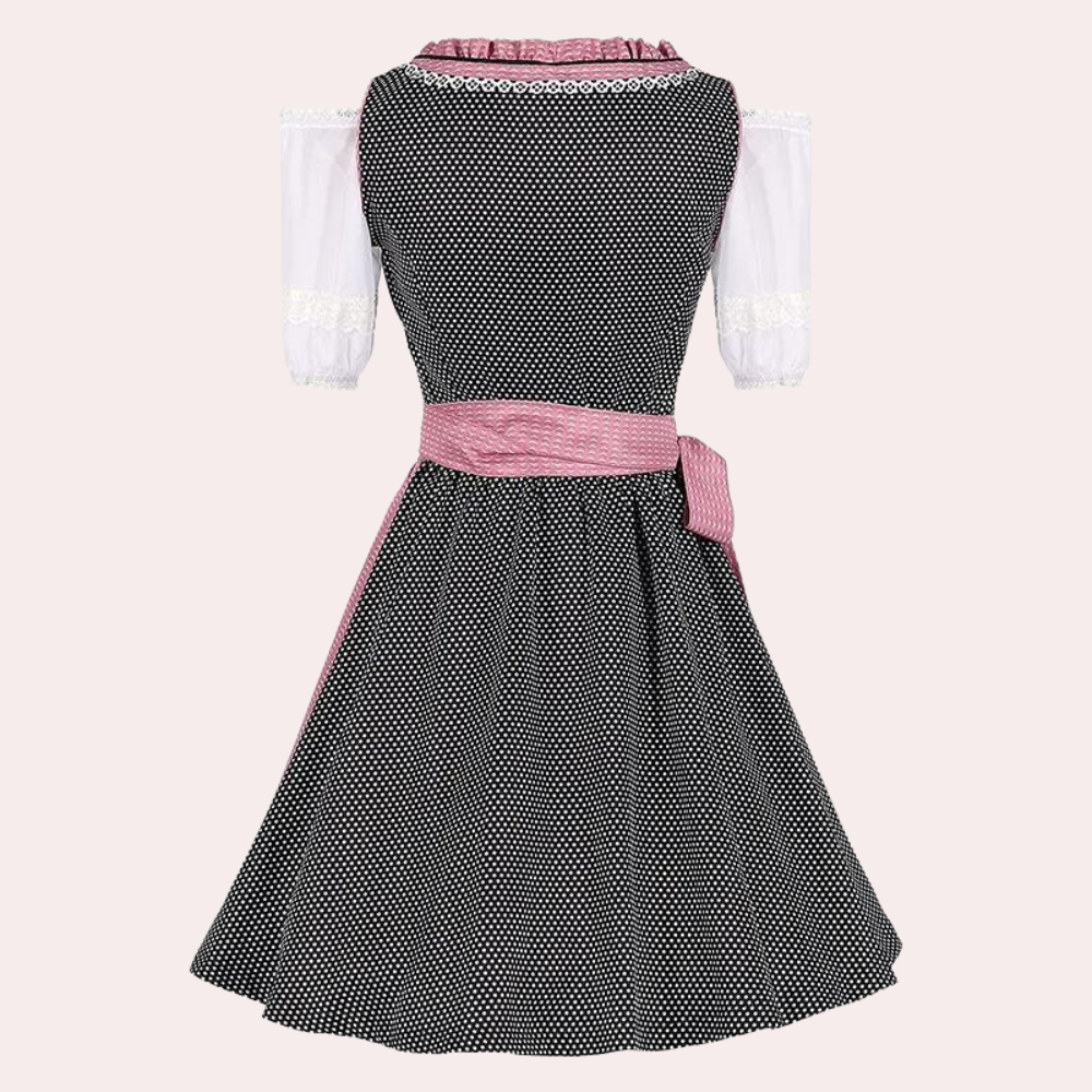 Zwarte retro jurk met witte stippen, roze riem en kanten details. Vintage damesmode, elegante polkadot stijl, perfecte zomerjurk.
