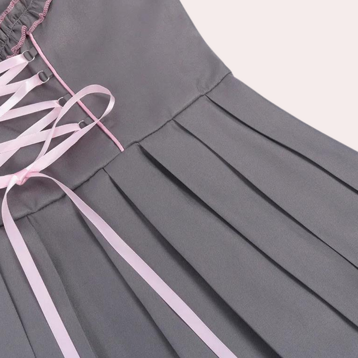 Grijze geplooide rok met roze veterdetail, elegante damesmode, stijlvolle kleding, trendy design, perfect voor casual en formele gelegenheden.