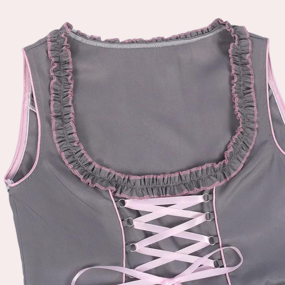 Grijze dirndl-blouse met roze ruches en veterdetail, traditionele Beierse kleding, Oktoberfest mode, dameskleding, feestelijke outfit.