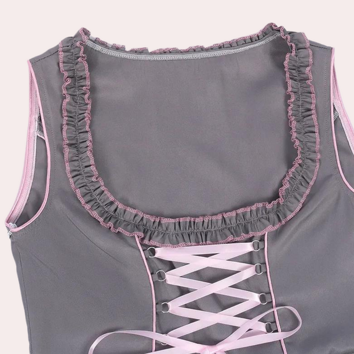 Grijze dirndl-blouse met roze ruches en veterdetail, traditionele Beierse kleding, Oktoberfest mode, dameskleding, feestelijke outfit.