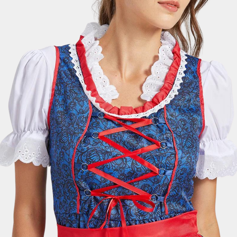 Vrouw in traditionele blauwe en rode dirndl met witte blouse en kanten details, Oktoberfest kleding, Beierse jurk, feestelijke outfit.
