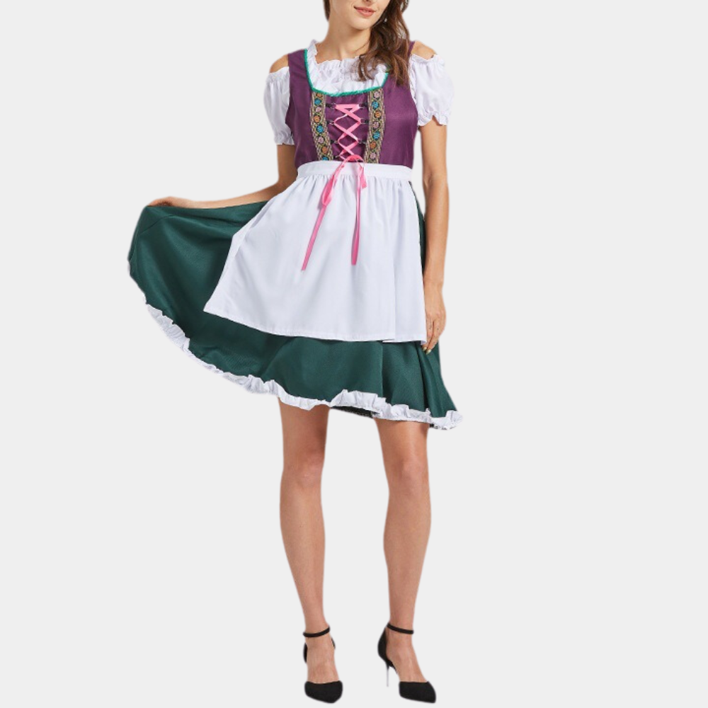 Vrouw in traditionele Duitse dirndl jurk met paarse top, groene rok en witte schort. Oktoberfest kleding, folkloristische mode.