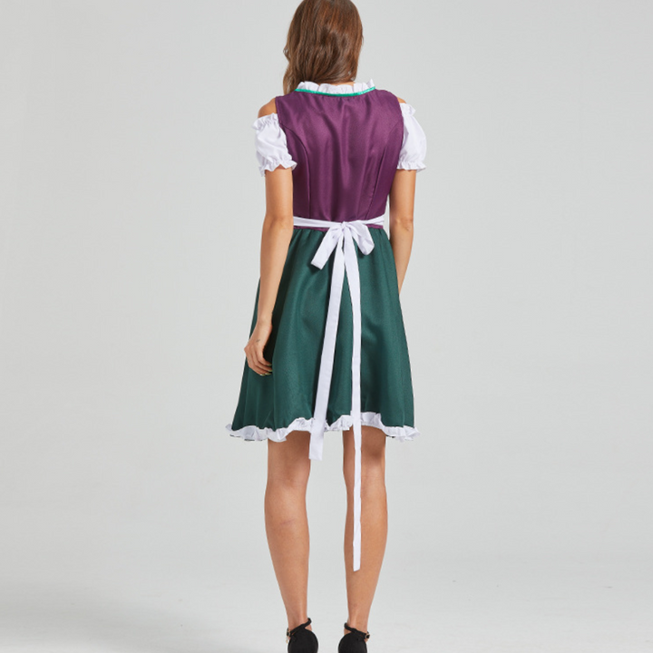 Vrouw in traditionele Duitse dirndl jurk, paars en groen, met witte schort en ruches. Oktoberfest kleding, achteraanzicht.