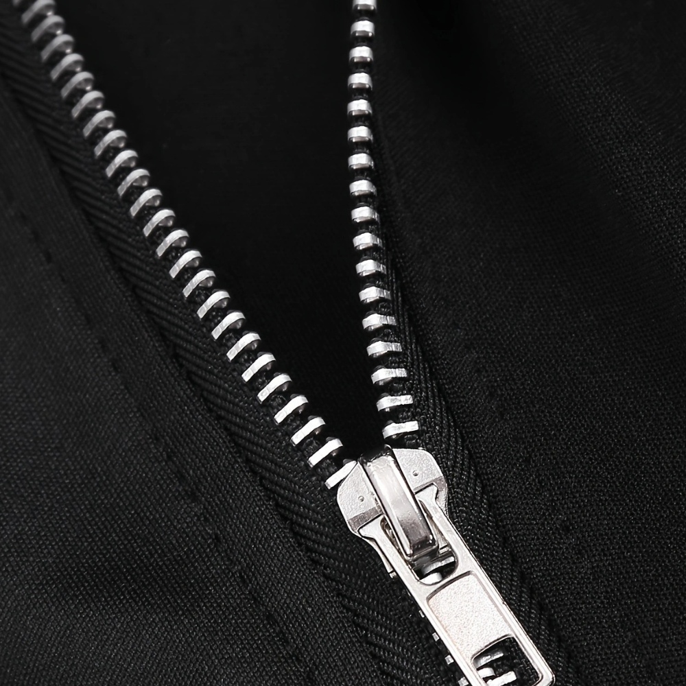 Zilverkleurige metalen ritssluiting op zwarte stof, close-up. Hoogwaardige rits, modeaccessoire, textiel, kledingdetail.