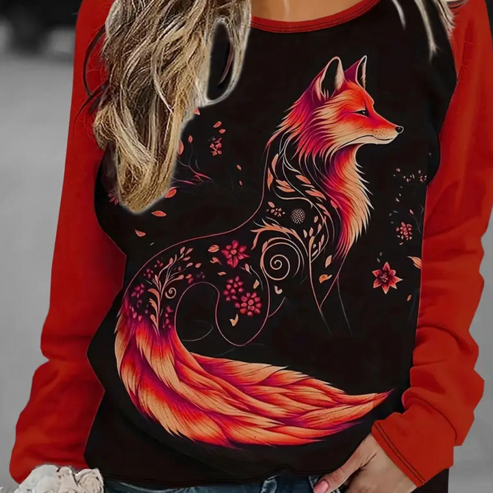 Vrouw draagt rood sweatshirt met artistieke vosprint, sierlijke patronen en bloemen. Modieuze dameskleding, herfstmode, casual stijl.