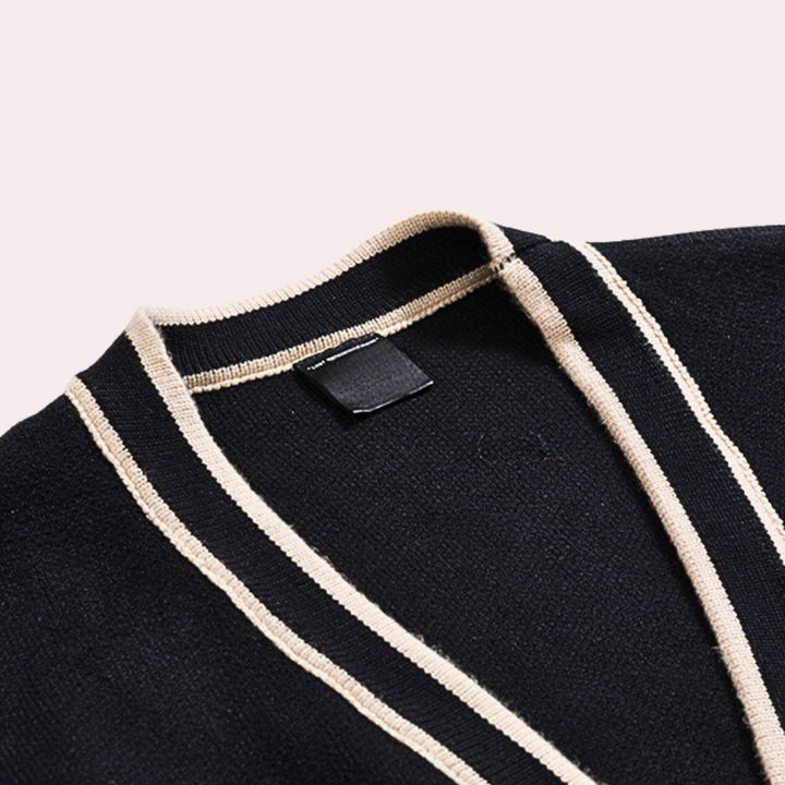 Zwarte cardigan met beige strepen, V-hals en label, close-up. Stijlvolle herenkleding, moderne mode, hoogwaardige stof, detailopname.