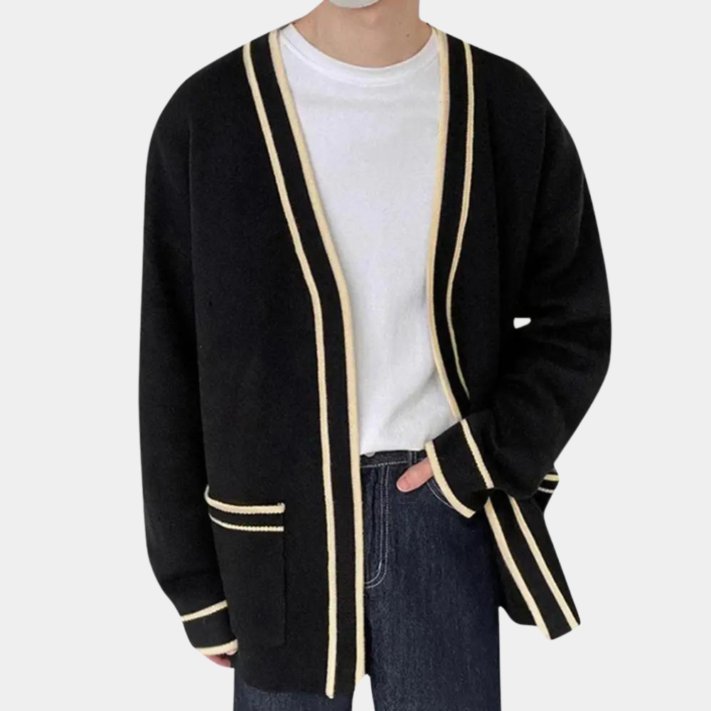Man in zwarte cardigan met witte strepen, witte T-shirt en donkere jeans. Stijlvolle herenkleding, casual outfit, modetrend 2023.