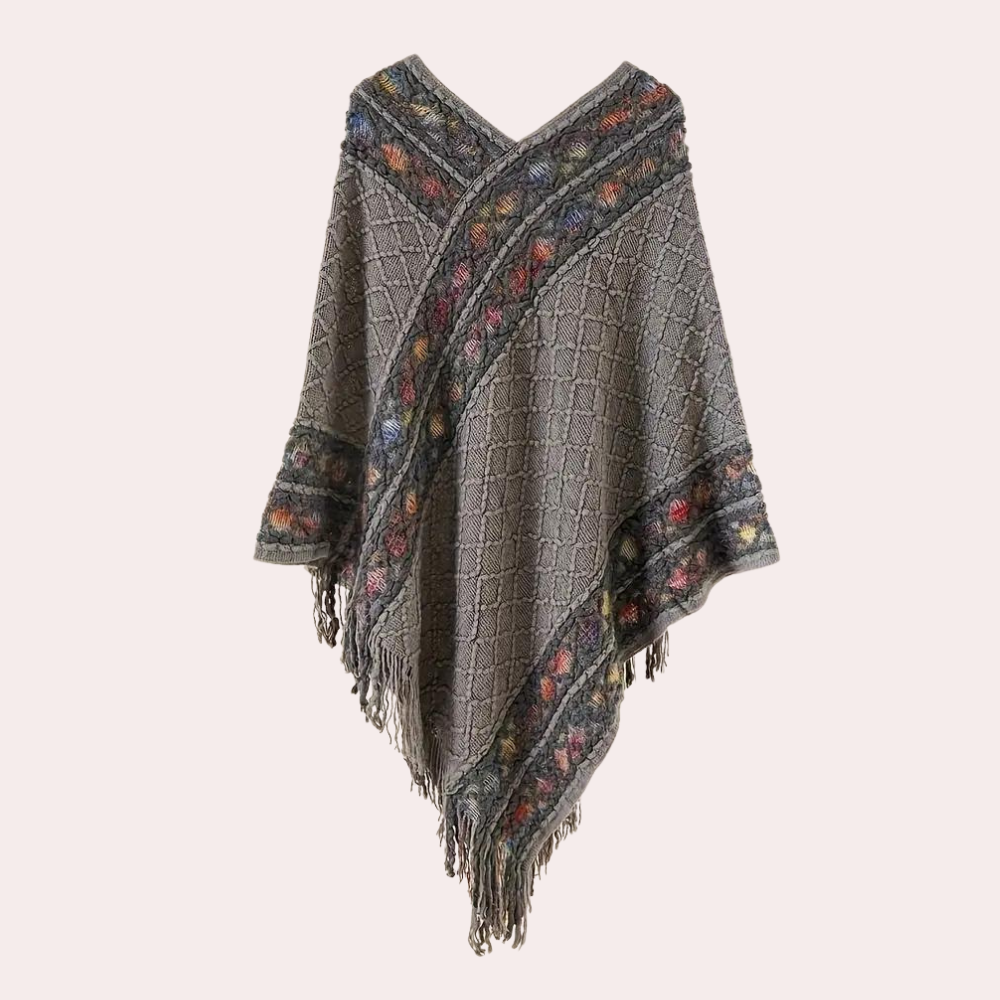 Grijze gebreide poncho met kleurrijke bloemenrand en franjes, damesmode, herfstkleding, boho-stijl, warme en stijlvolle omslagdoek.