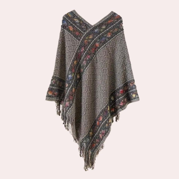 Grijze gebreide poncho met kleurrijke bloemenrand en franjes, damesmode, herfstkleding, boho-stijl, warme en stijlvolle omslagdoek.