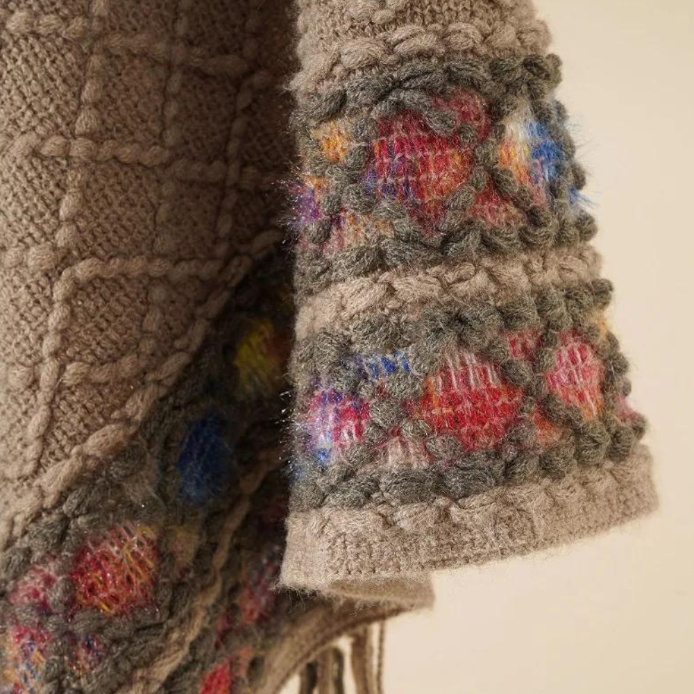 Beige gebreide trui met kleurrijke, gehaakte details en franjes. Handgemaakt design, warme wintermode, unieke textuur, bohemian stijl.