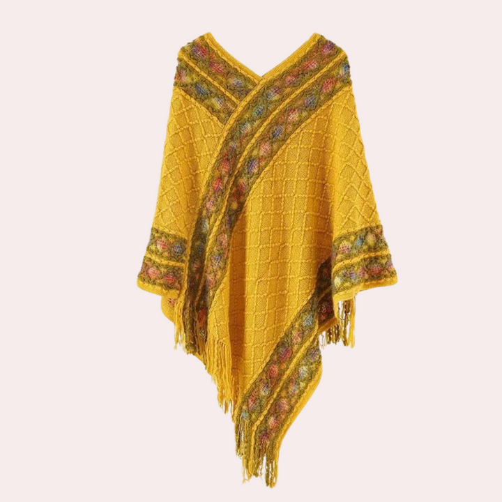 Gele gebreide poncho met kleurrijke franjes en ruitpatroon, damesmode, herfstkleding, warme wollen omslagdoek, bohemian stijl.