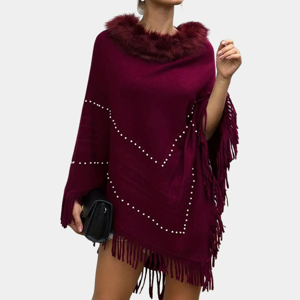 Vrouw draagt bordeauxrode poncho met nepbontkraag en franjes, versierd met parels. Modieuze herfstkleding, elegant en stijlvol ontwerp.