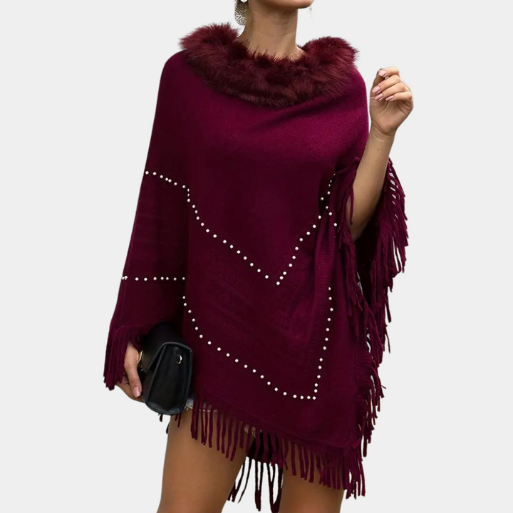 Vrouw draagt bordeauxrode poncho met nepbontkraag en franjes, versierd met parels. Modieuze herfstkleding, elegant en stijlvol ontwerp.