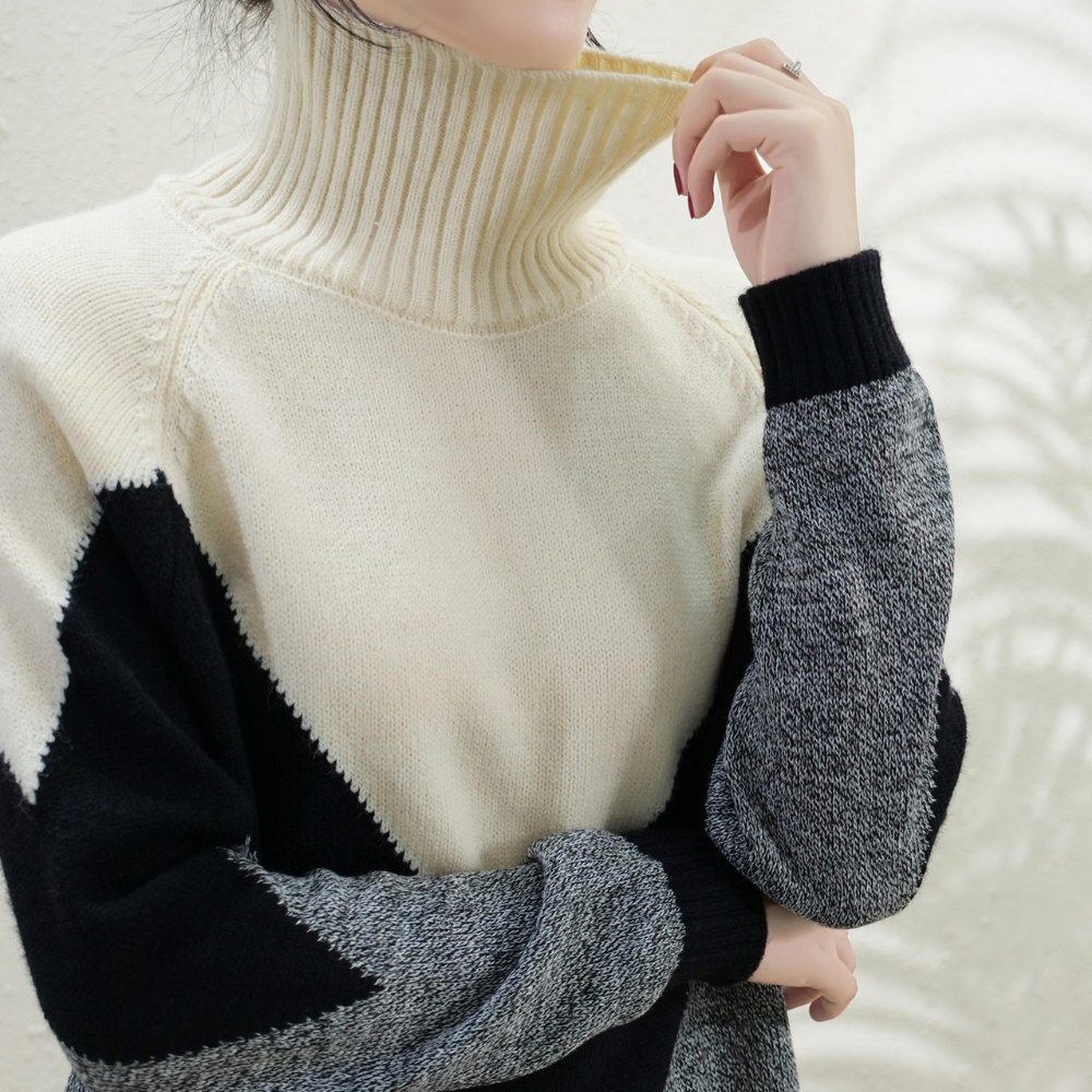 Vrouw in stijlvolle gebreide trui met col, zwart-wit-grijs patroon. Modieuze winterkleding, warme damestrui, trendy design.