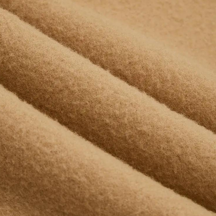 Close-up van beige wollen stof, zachte textuur, geschikt voor winterkleding en interieurdecoratie. Hoogwaardige wol, duurzaam en warm.