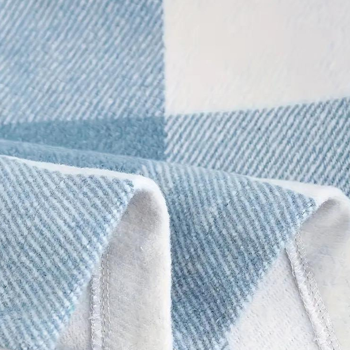 Blauwe geruite deken met zachte textuur, close-up. Perfect voor interieurdecoratie, comfort en warmte. Hoogwaardige stof, modern design.