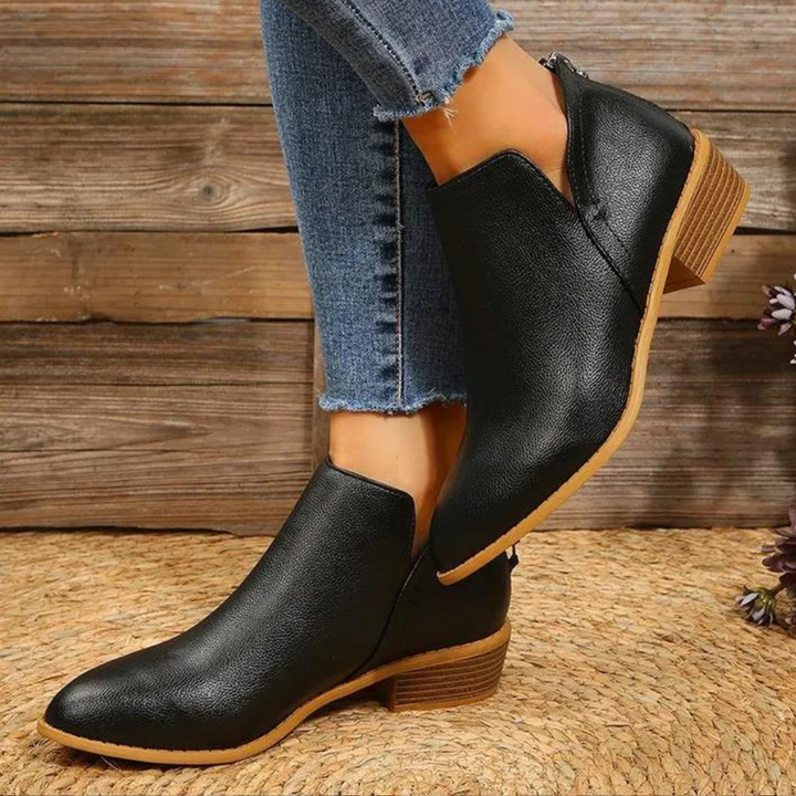 Zwarte leren enkellaarsjes met lage hak, gedragen met blauwe jeans. Stijlvolle damesmode, perfect voor casual en chique outfits.