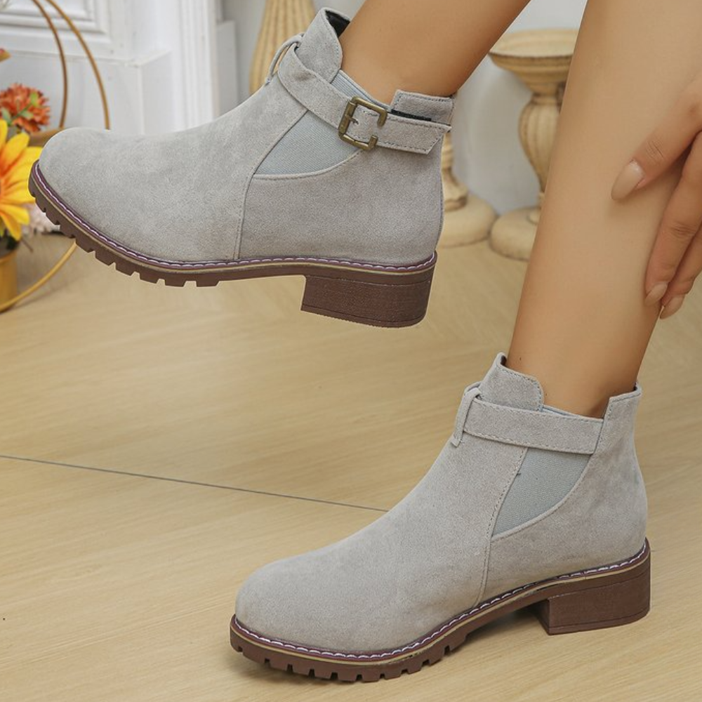 Grijze suède enkellaarsjes met gesp, blokhak en elastische inzet. Stijlvolle dameslaarzen voor herfstmode. Comfortabele en trendy schoenen.