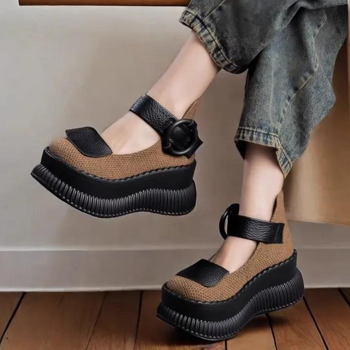 Zwarte en bruine platform schoenen met dikke zolen en verstelbare bandjes, gedragen door een persoon in jeans. Modieuze dames schoenen.