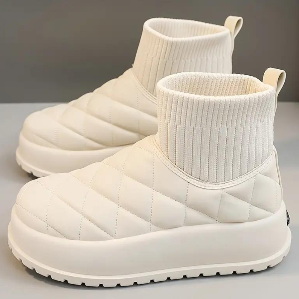Witte gewatteerde enkellaarsjes met geribbelde sokboord, dikke zool en antislipprofiel. Trendy winterlaarzen voor dames, comfortabel en stijlvol.