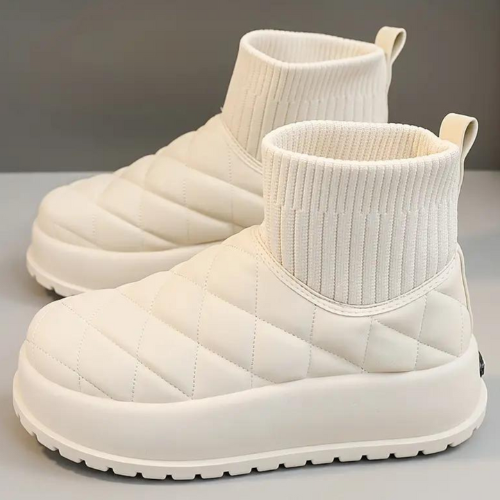 Witte gewatteerde enkellaarsjes met geribbelde sokboord, dikke zool en antislipprofiel. Trendy winterlaarzen voor dames, comfortabel en stijlvol.