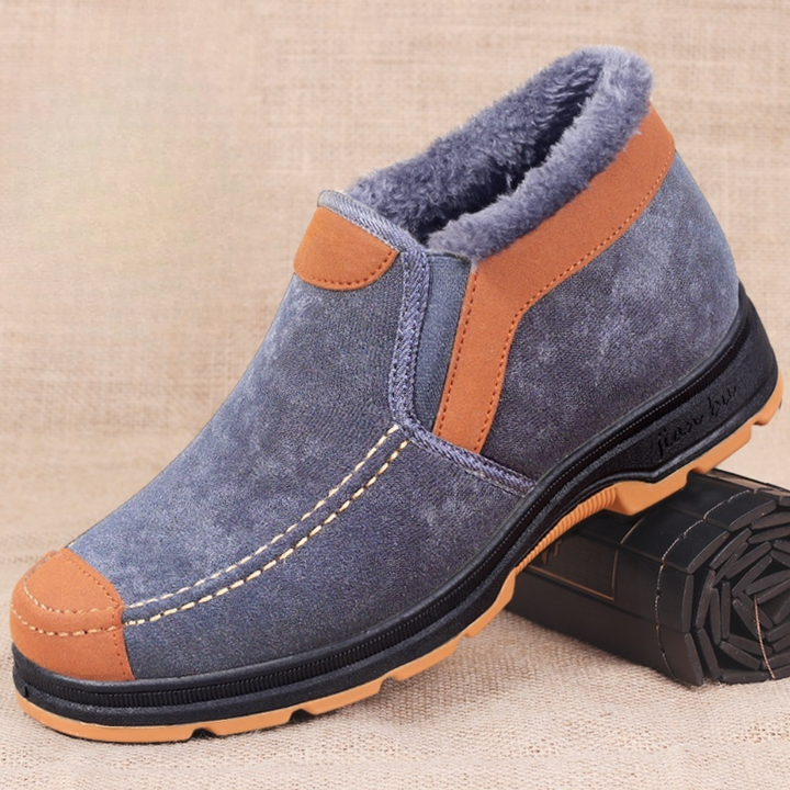 Grijze suède herenschoen met bruine accenten, warme voering en stevige rubberen zool, ideaal voor wintermode en casual comfort.