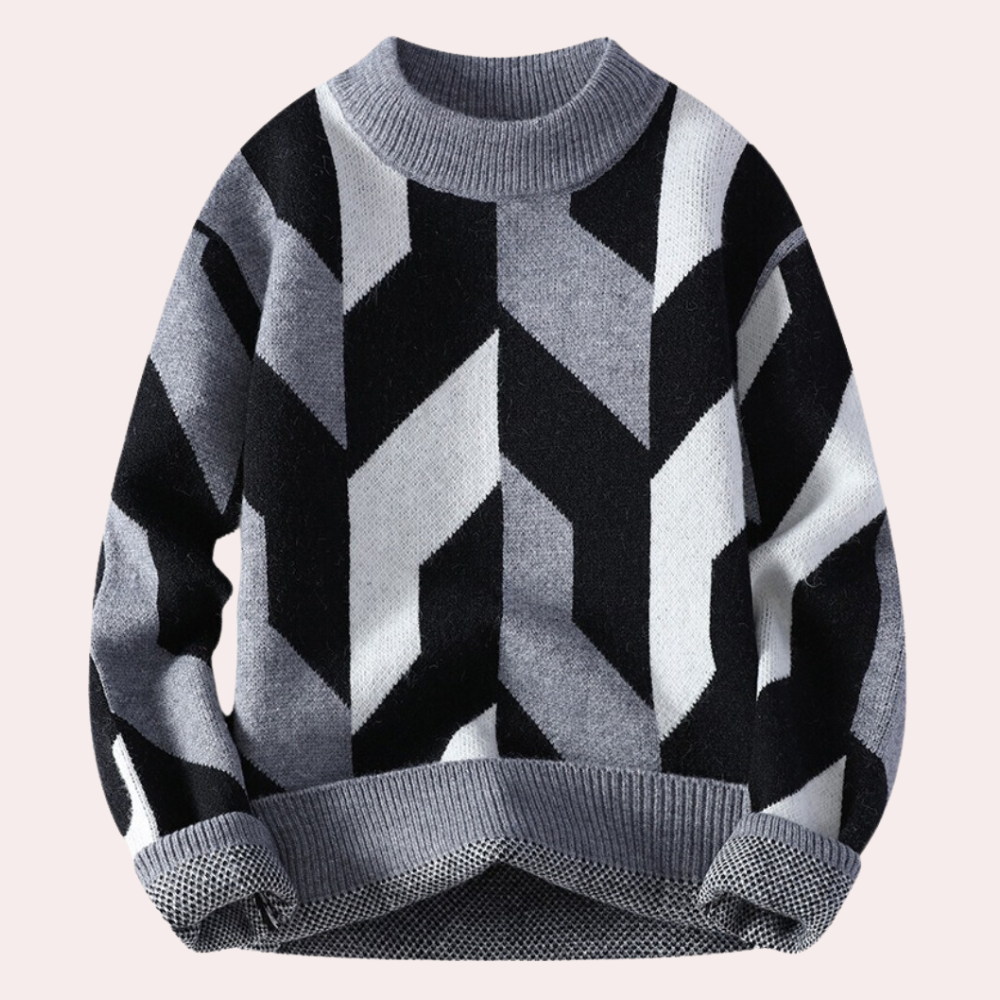 Grijze trui met geometrisch zwart-wit zigzagpatroon, ronde hals en geribde boorden. Moderne herentrui, wintermode, warme kleding.