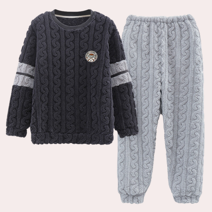 Donkergrijze gebreide kinderpyjama set met kabelpatroon, bestaande uit een trui en broek. Comfortabel en warm, ideaal voor koude nachten.