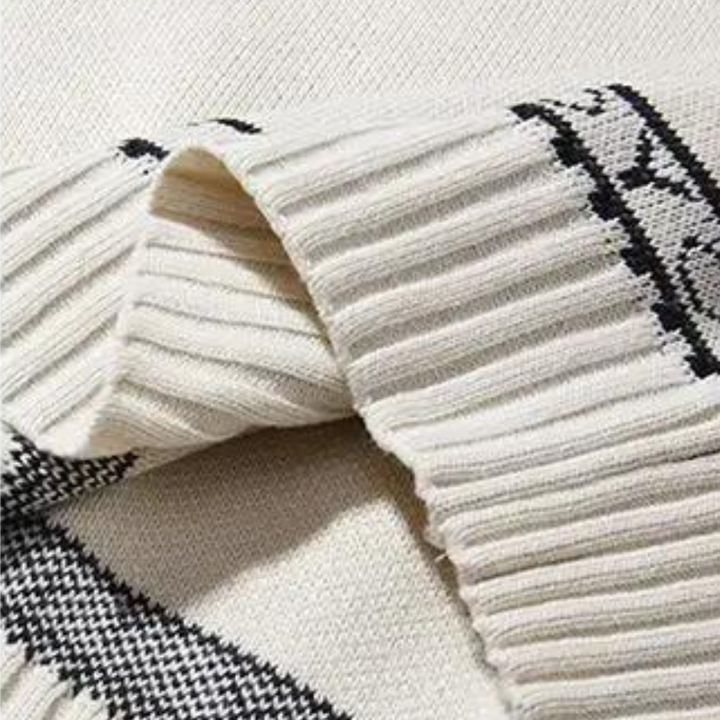 Crèmekleurige gebreide trui met zwart-wit patroon, ribgebreide boorden en gedetailleerd textuurontwerp. Perfect voor wintermode en casual stijl.