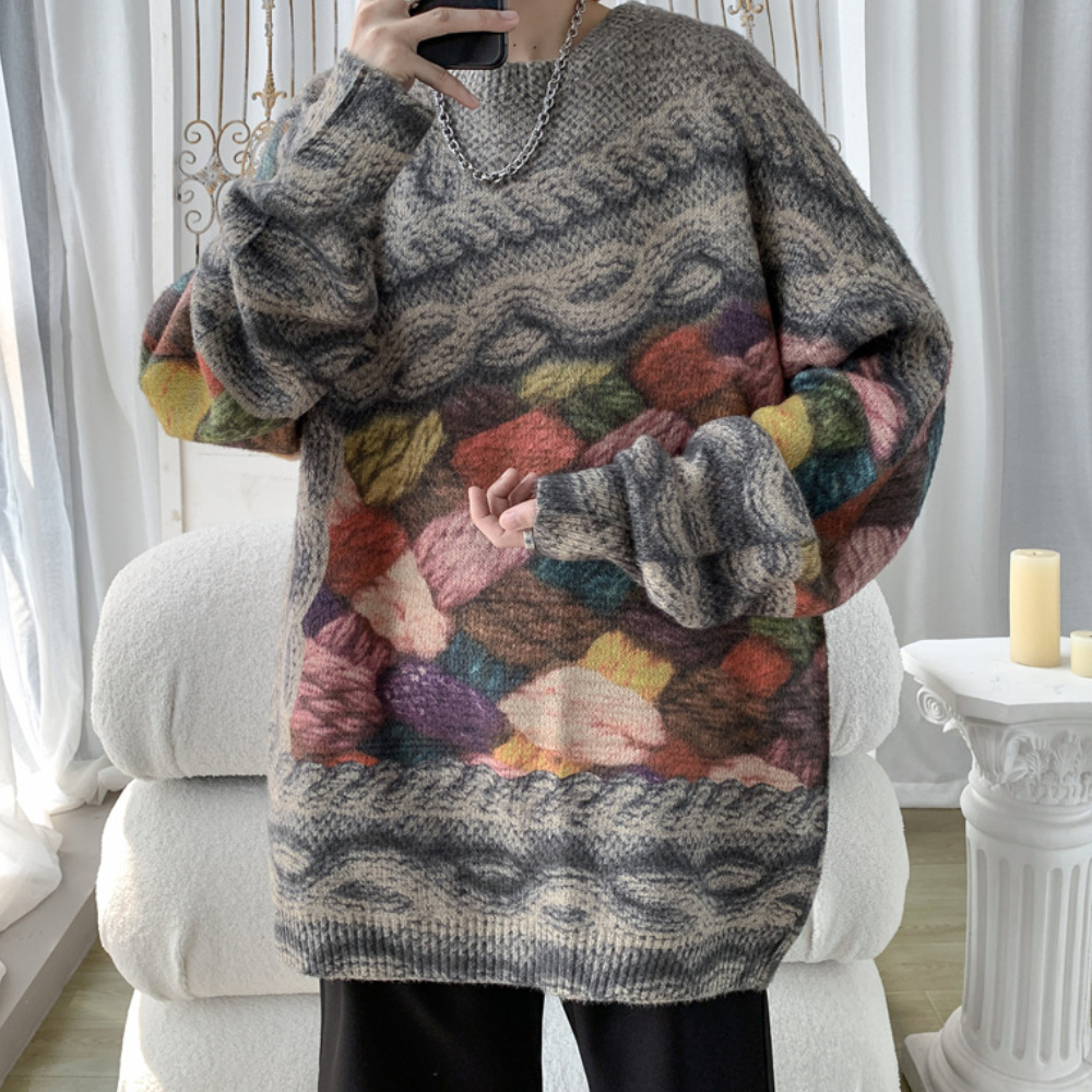 Grofgebreide oversized trui met kleurrijk patroon, grijze en beige tinten, geschikt voor herfstmode. Comfortabele en stijlvolle dameskleding.