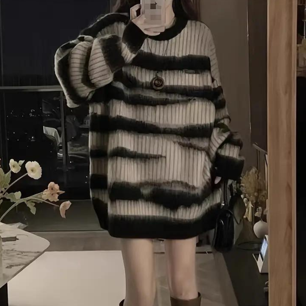 Vrouw in oversized zwart-wit gestreepte trui, selfie in moderne woonkamer. Trendy mode, comfortabele kleding, herfst-winter stijl.