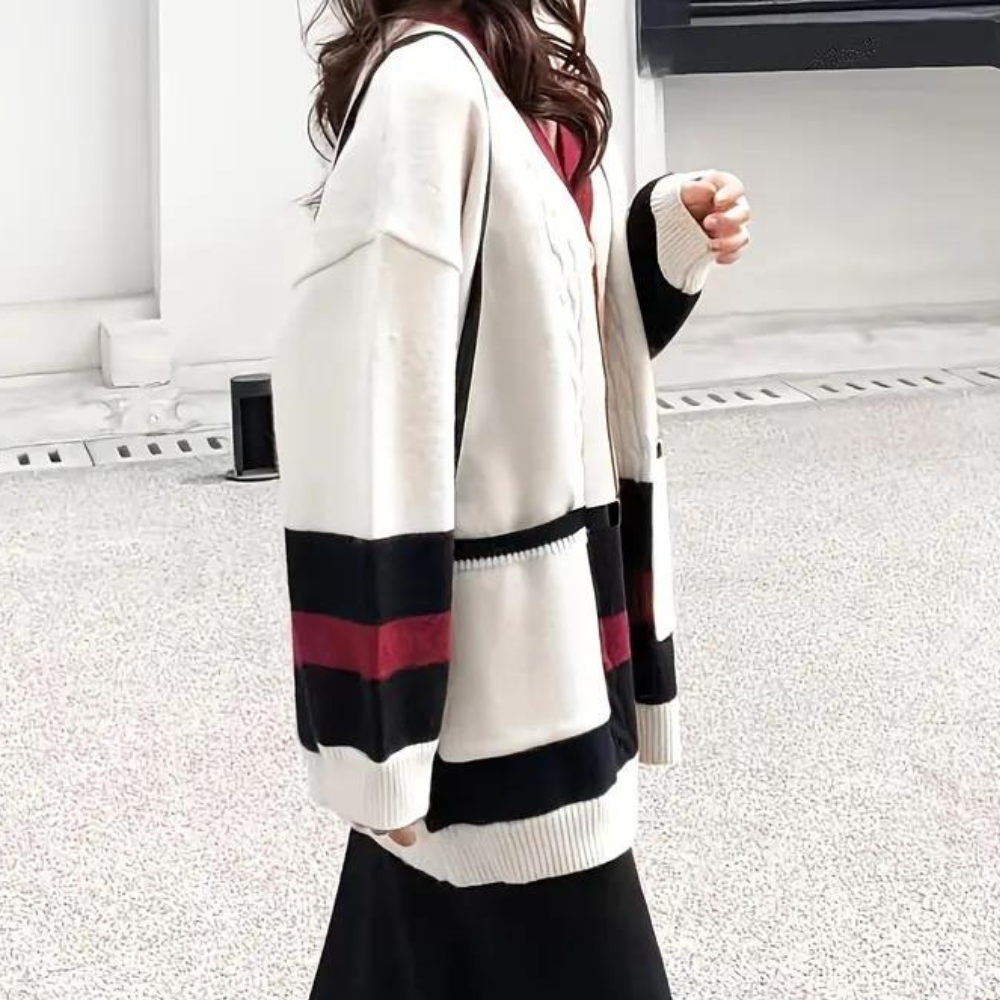 Vrouw in stijlvolle, oversized cardigan met zwart-witte strepen en rode accenten. Modieuze dameskleding, herfstoutfit, casual chic look.