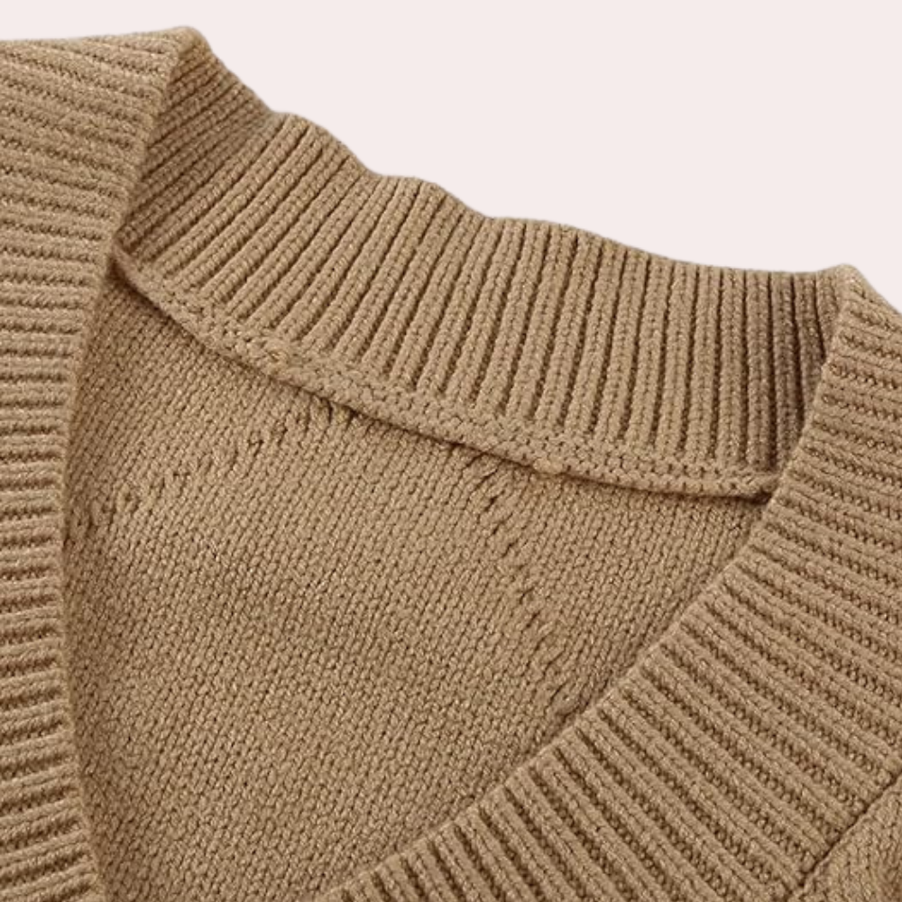 Beige gebreide trui met geribbelde V-hals en kraag, close-up detail. Modieuze dameskleding, herfst- en wintermode, comfortabele stof.