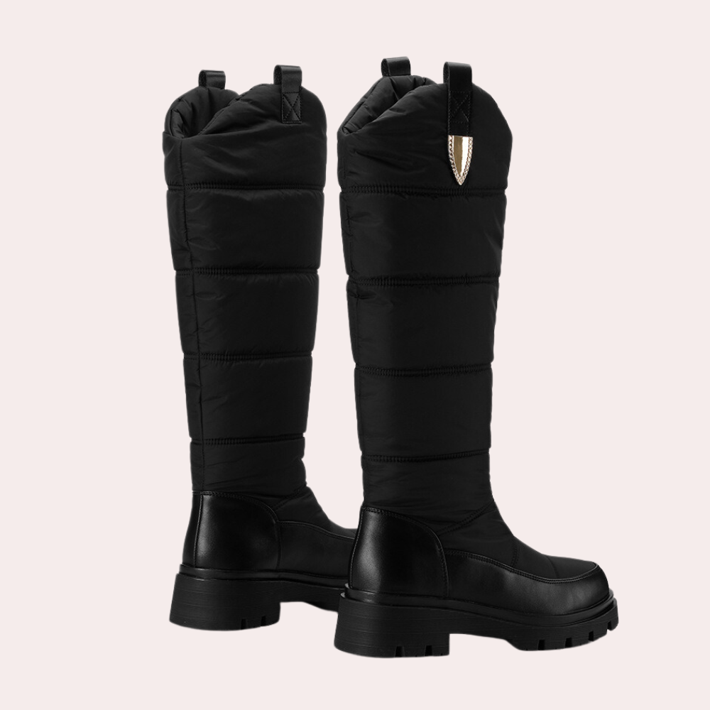 Zwarte gewatteerde laarzen met dikke zool, hoge schacht en decoratieve stiksels. Modieuze winterlaarzen voor dames, ideaal voor koude seizoenen.