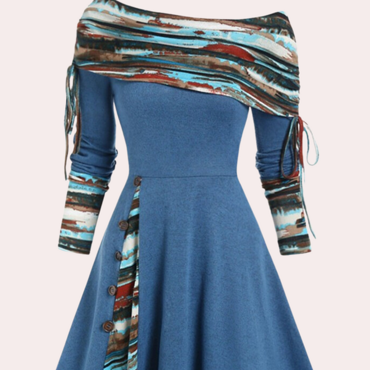 Blauwe jurk met asymmetrische halslijn en kleurrijke sjaalprint, knoopdetails en lange mouwen. Modieuze dameskleding, herfstcollectie.