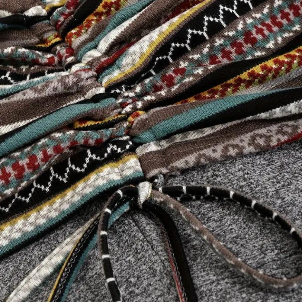Close-up van kleurrijke, gestreepte gebreide stof met etnisch patroon en trekkoord detail. Perfect voor mode, textiel en design inspiratie.