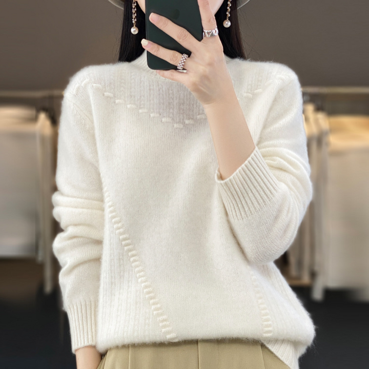 Vrouw in witte trui met textuur, houdt smartphone vast. Modieuze winterkleding, casual stijl, comfortabele pasvorm, trendy accessoires.