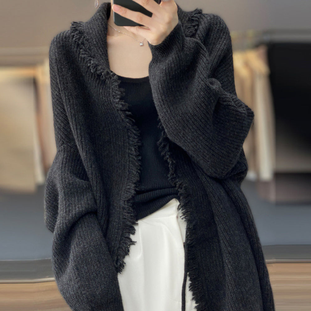 Zwarte gebreide damesvest met franjes, casual en stijlvol, perfect voor herfst- en wintermode. Comfortabel en veelzijdig kledingstuk.